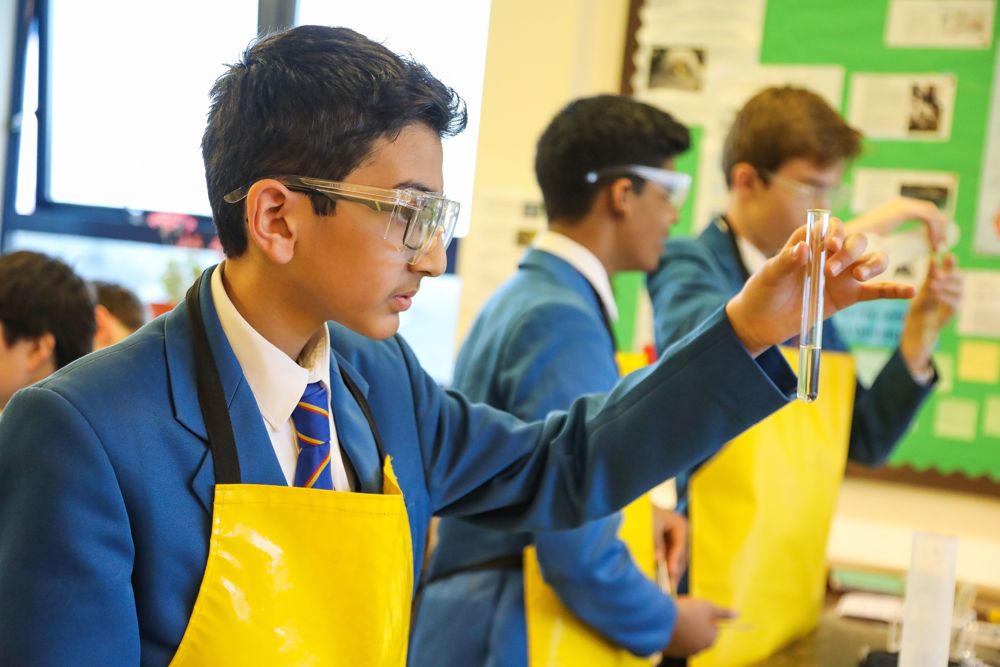 Three pupils carrying out experiments with test tubes