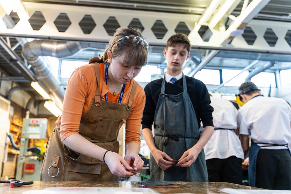 DT teacher demonstrating a practical technique to a student